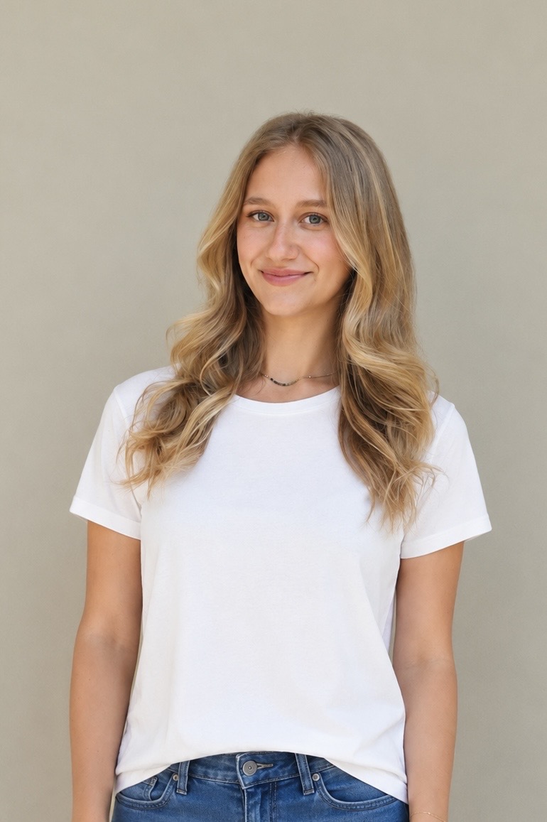 Miriam, a certified health and wellness coach, smiling in a white t-shirt against a sage green background